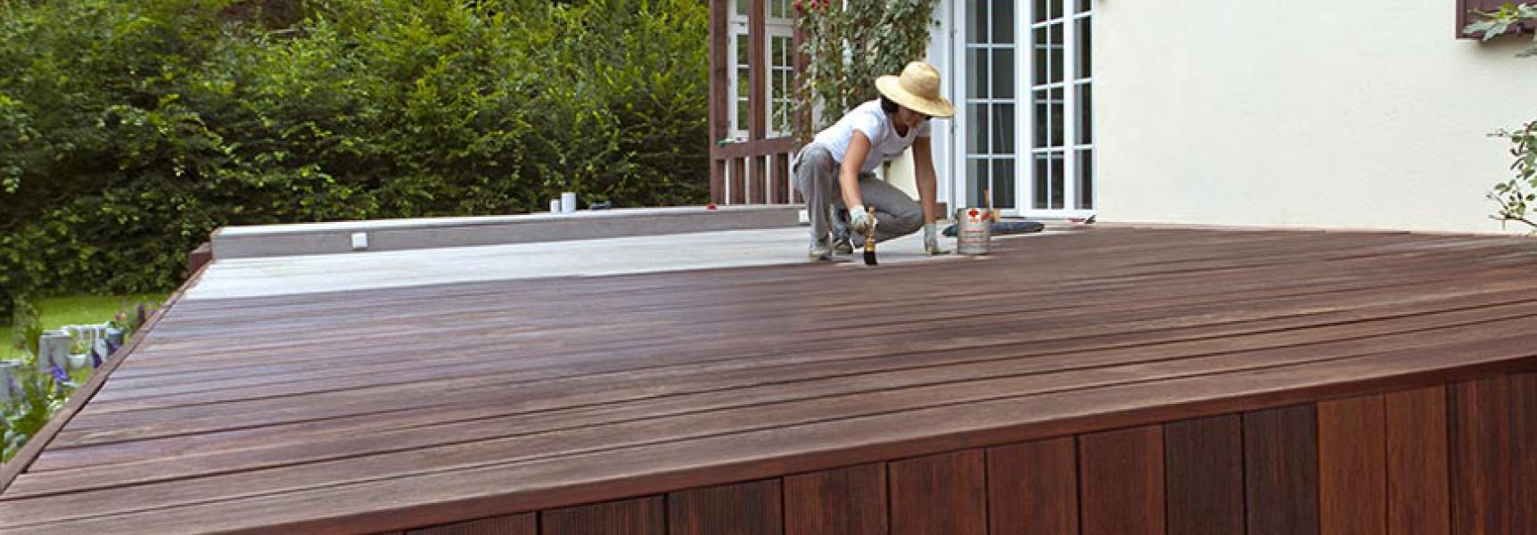 Woman paints terrace with terrace wood oil